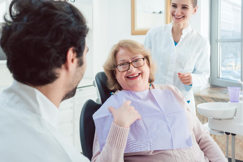 Older woman smiling at dentist in dental chair, lindenhurst ny
