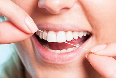 Close up of woman flossing her teeth, lindenhurst ny