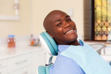 Black man in dentist chair about to get composite bonding, Lindenhurst NY