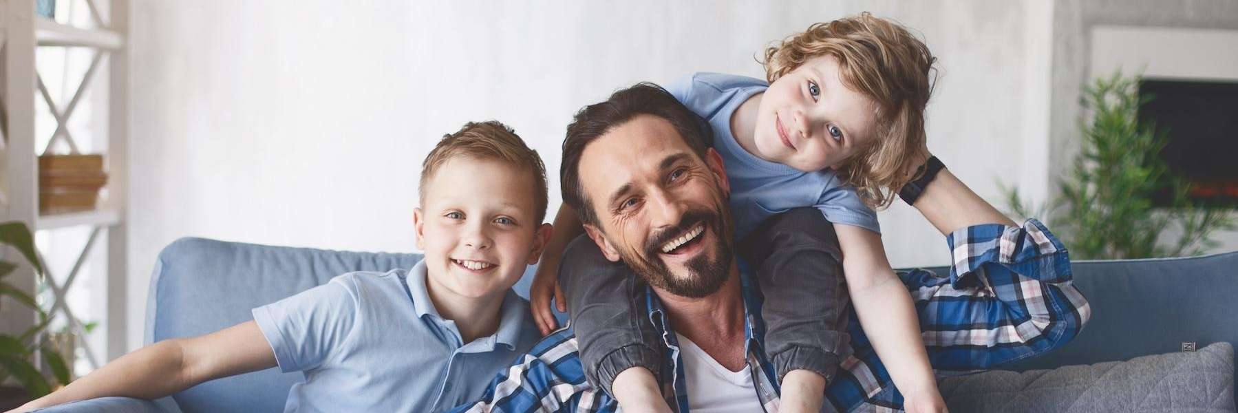 Father smiling with two kids on couch, lindenhurst ny