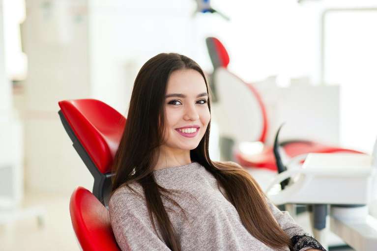 Woman smiling in dental chair before cerec crowns, lindenhurst ny