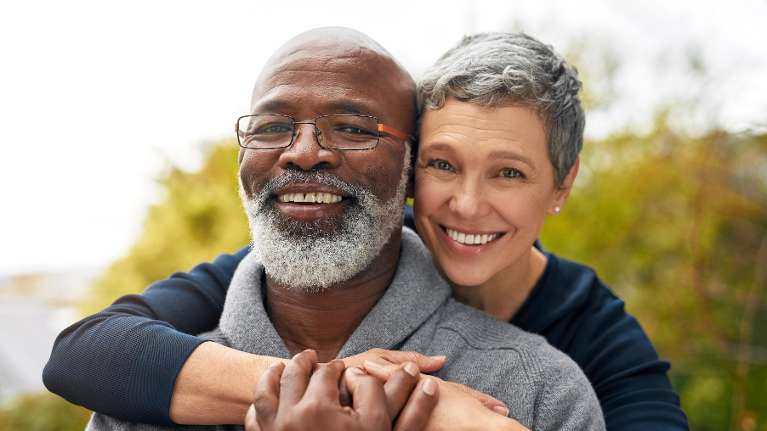 Older black man and white woman embracing and smiling, lindenhurst ny