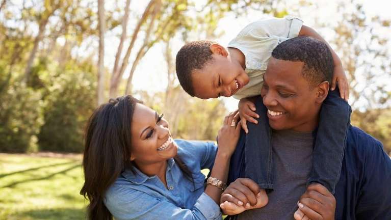 Black mother, father, and son all smiling together outside, lindenhurst ny